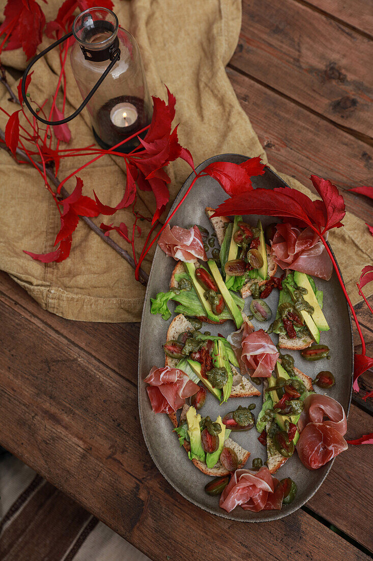 Canapes with Serrano ham and avocado on an autumnally decorated table