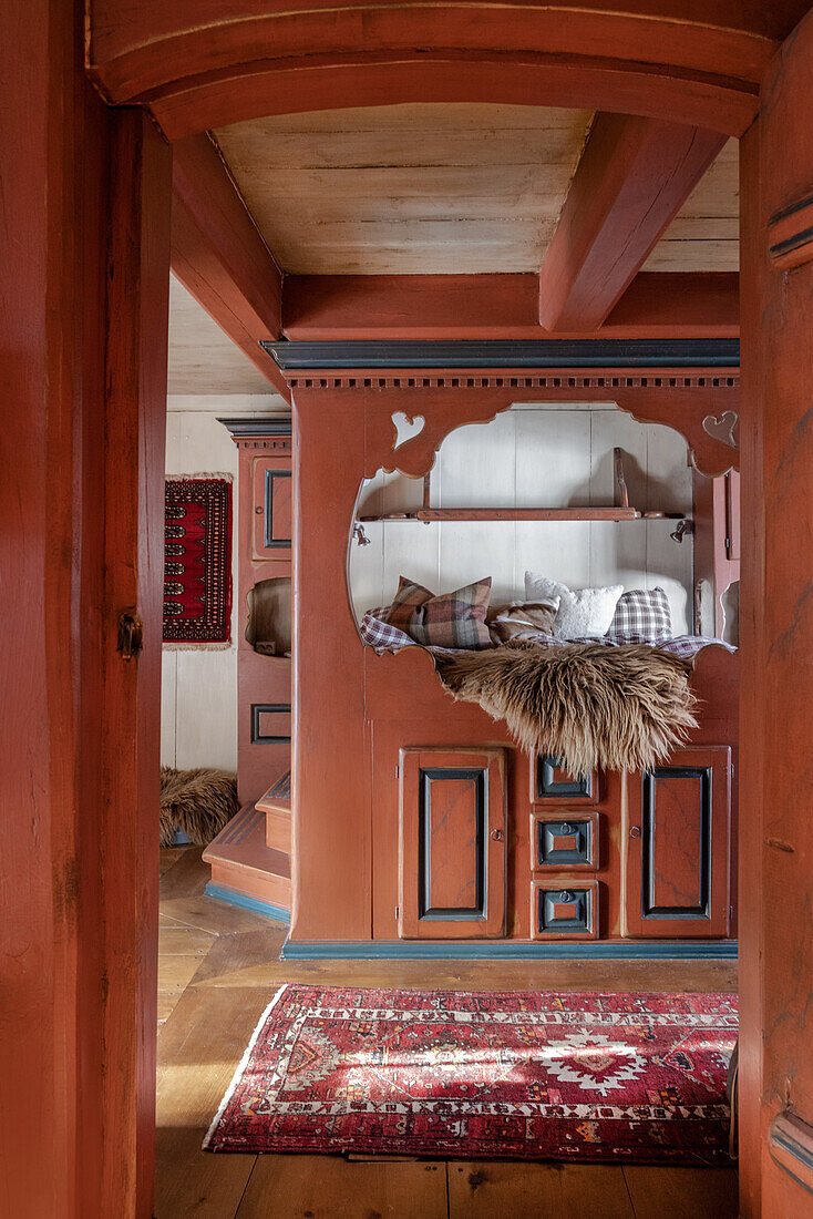 Traditionally furnished farmhouse parlour with carvings and red patterned carpet