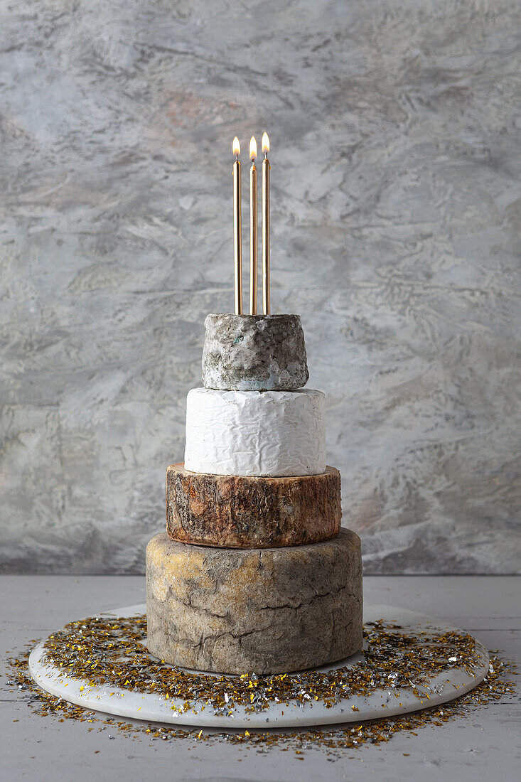 Cheese Wedding Cake - wheels of Cheeses arranged as a multi-tier wedding cake, with candles and golden candles
