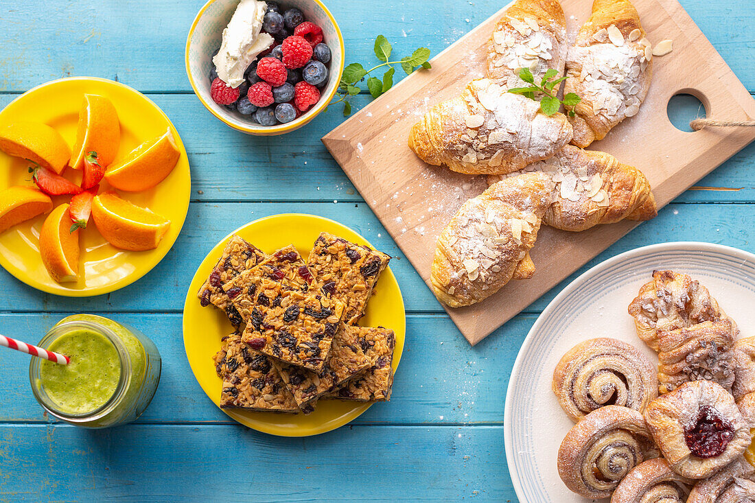 Breakfast buffet with croissants, cinnamon buns, flapjack, smoothie and fruit