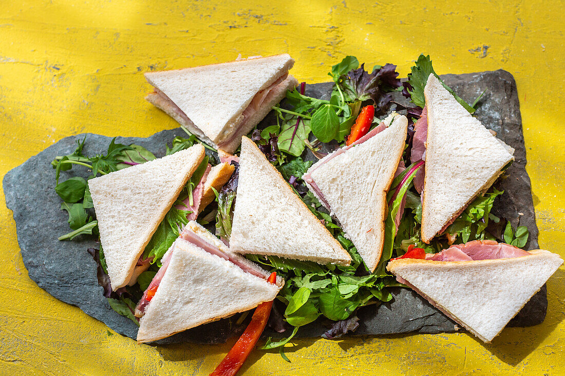 Sandwichecken mit Schinken auf Salatblättern