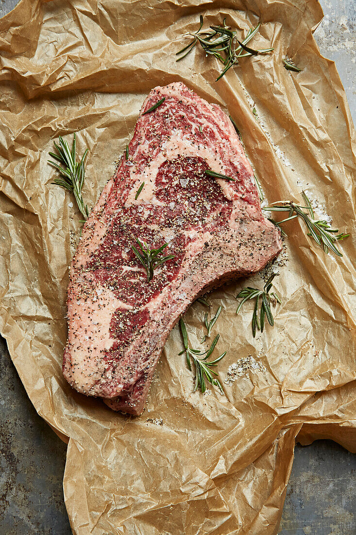 Large steak with rosemary, salt and pepper