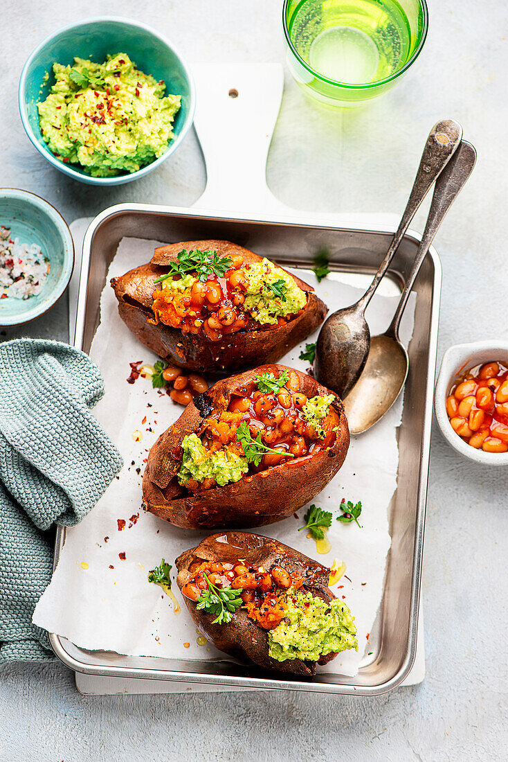 Stuffed baked sweet potatoes with guacamole and beans