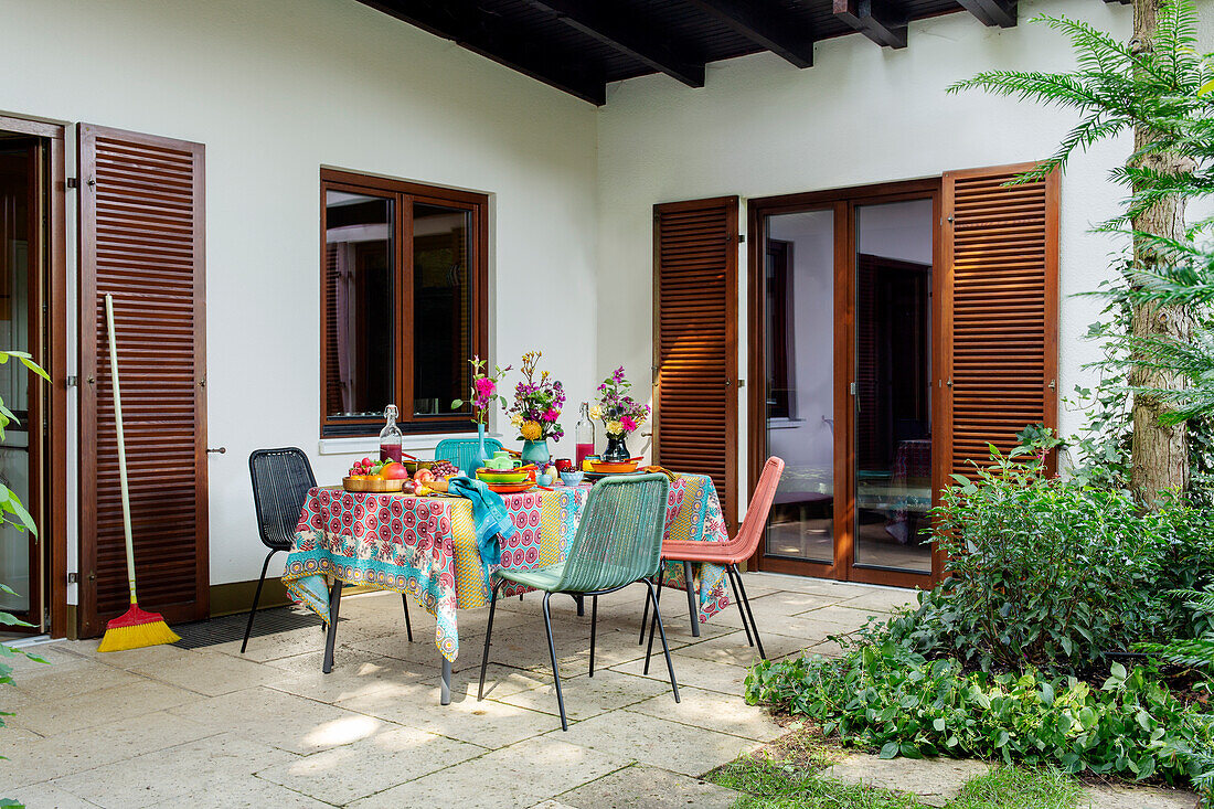 Terrace with colorful table setting and colorful chairs