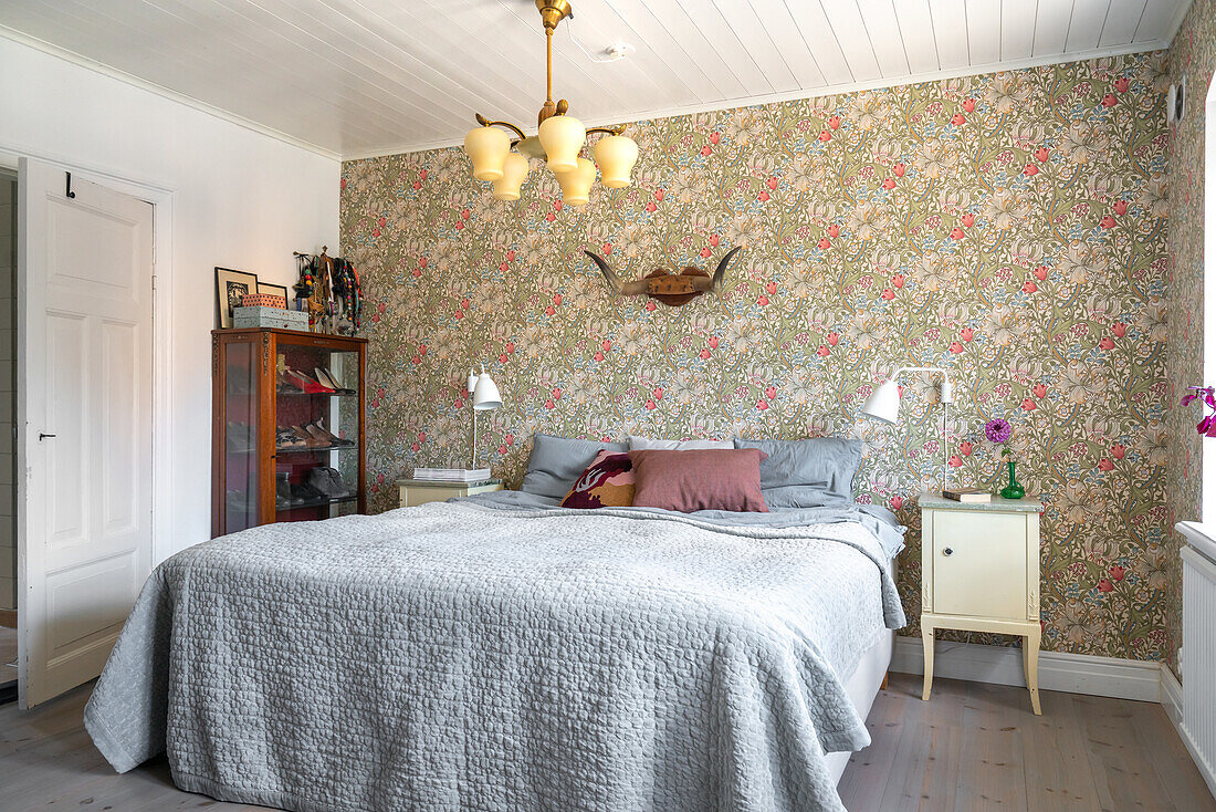 Bedroom with floral wallpaper and vintage lamp