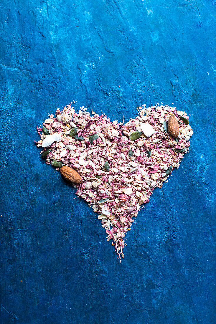 Beetroot granola in heart shape on a blue background