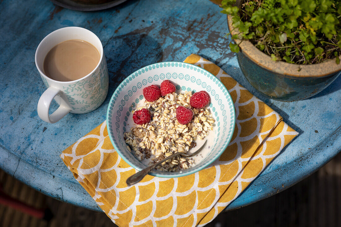 Muesli with raspberries and milk and a cup of coffee