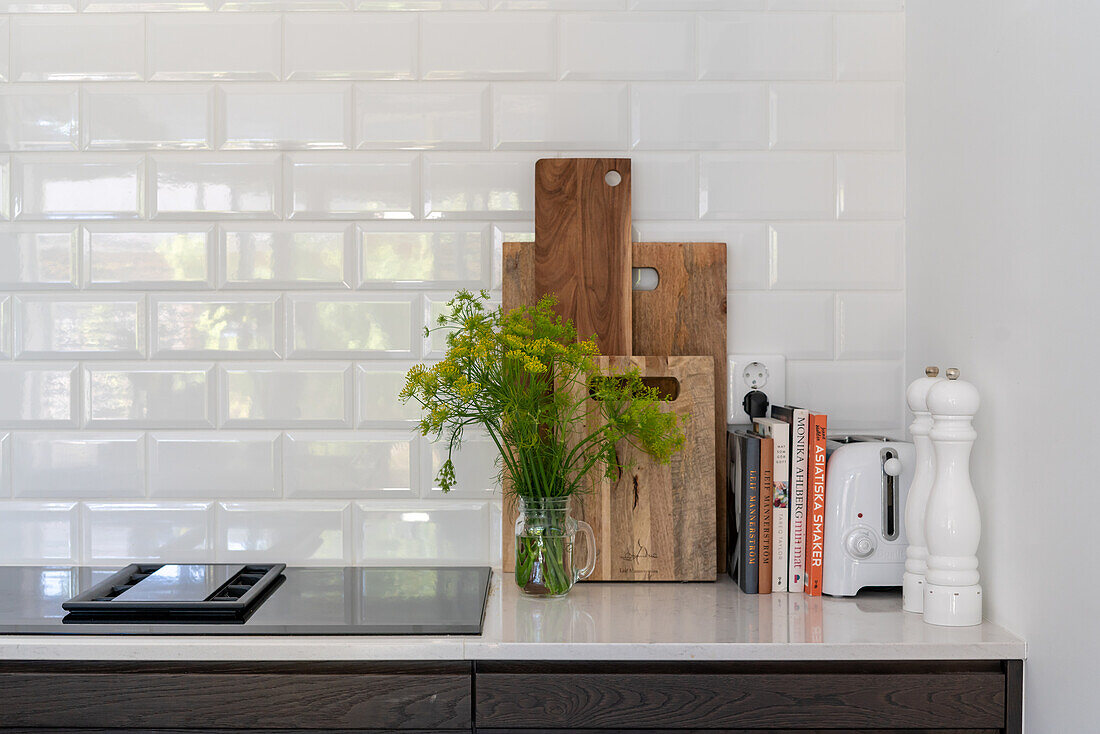 Küchenarbeitsfläche mit Holzschneidebrettern und Kochbüchern, Metrofliesen