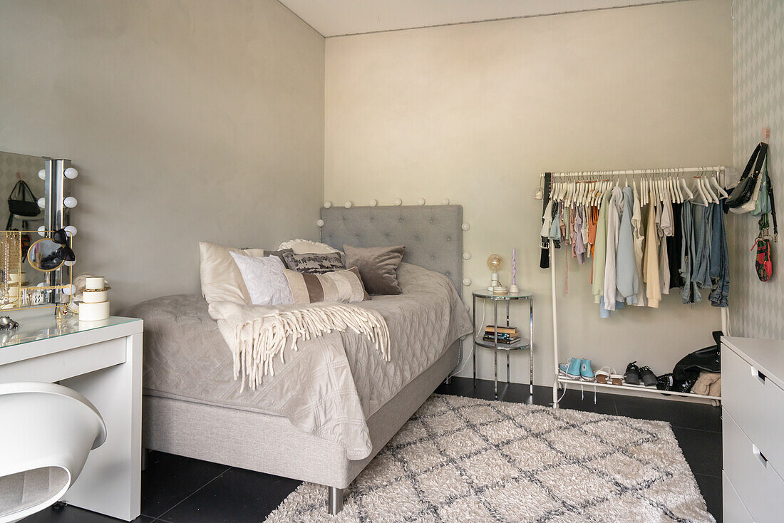 Bedroom with clothes rack, dressing table and carpet