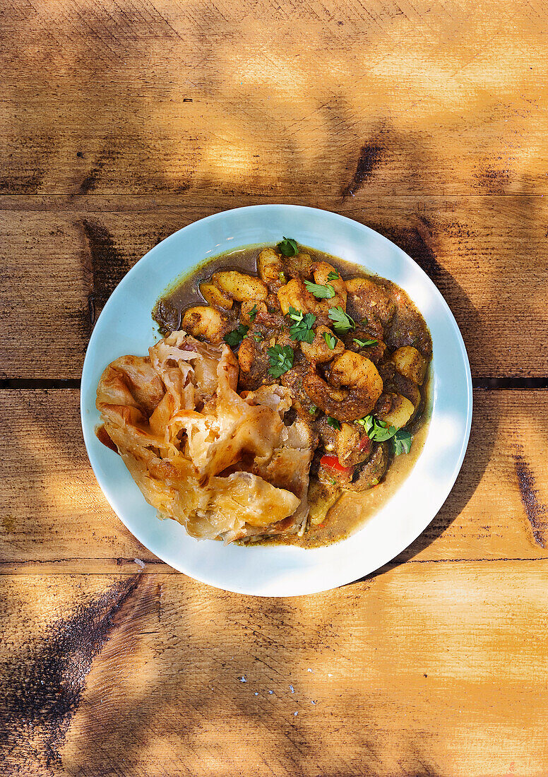 Trinidadische Curry-Garnelen serviert mit Paratha