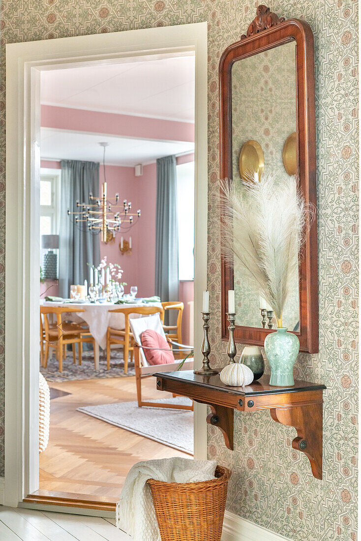 Hallway with console and mirror, view into the dining room with chandelier