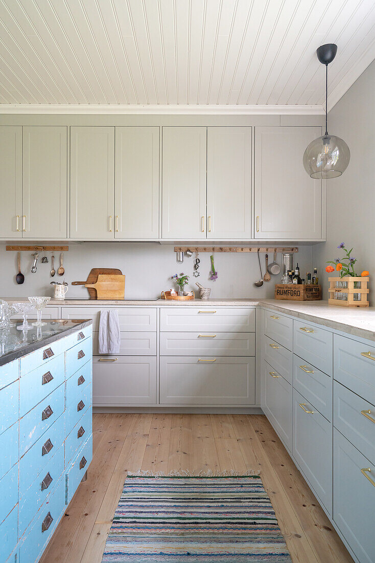 Bright country kitchen with white wooden ceiling and wooden floor