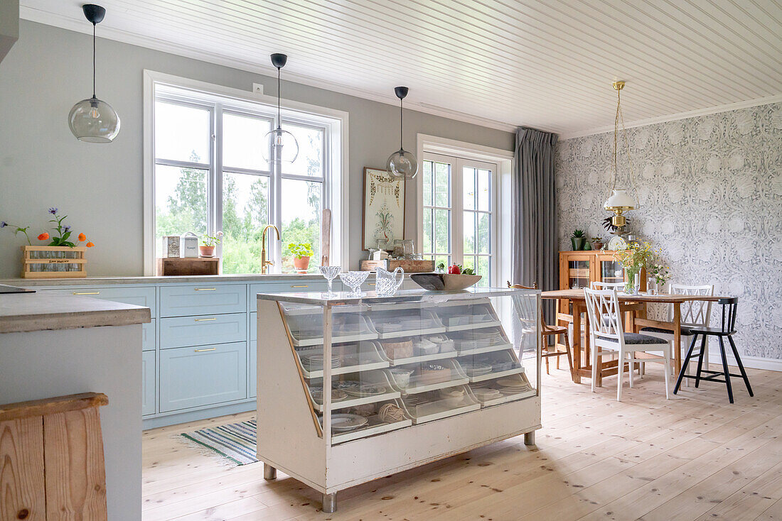 Light-coloured country kitchen with vintage kitchen island and dining area