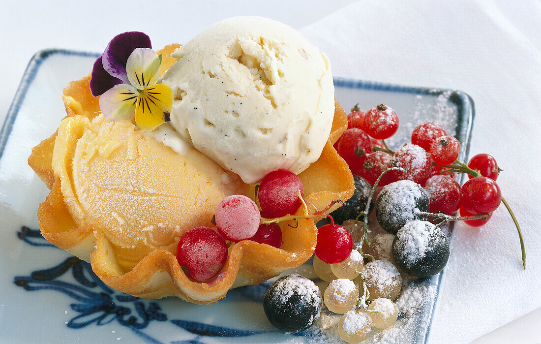 Melon and vanilla ice cream in waffle bowls served with fresh and frozen currants