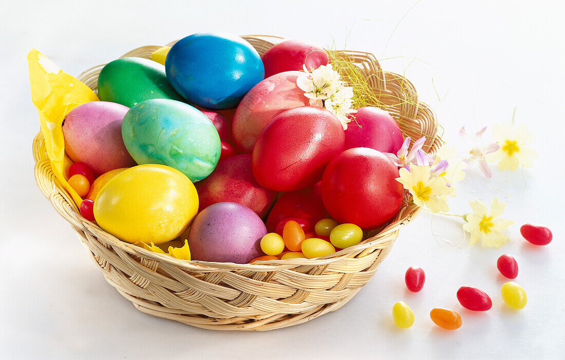 Basket with colorful Easter eggs and sugar eggs