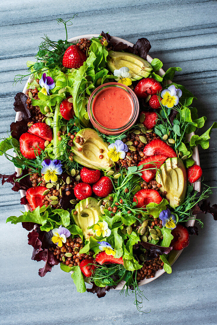 Bunter Salat mit Erdbeeren, Avocado, Essblüten und Erdbeer-Dressing