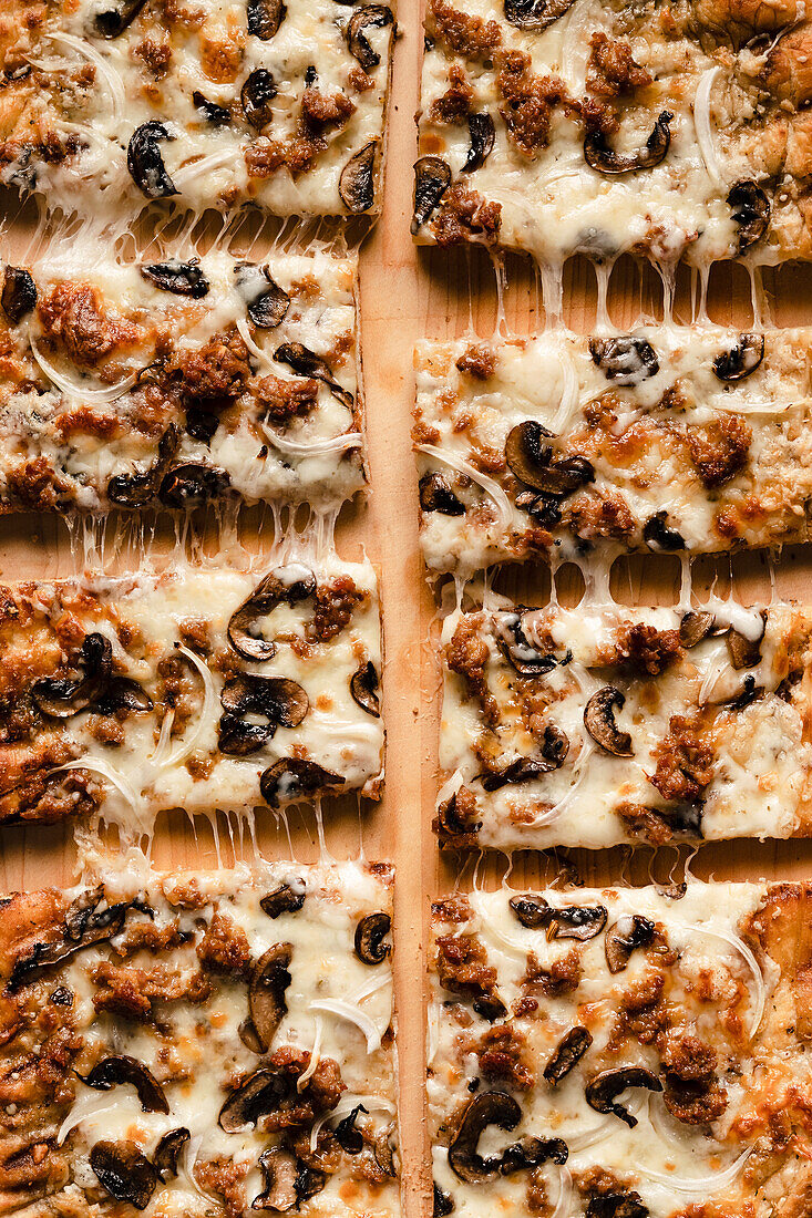 Overhead view of a sliced mushroom, onion and sausage grilled pizza