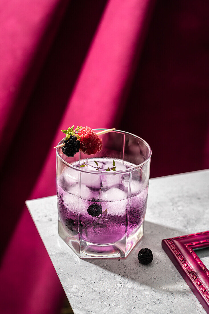 Erfrischender violetter Cocktail mit Brombeer-Himbeer-Spießchen