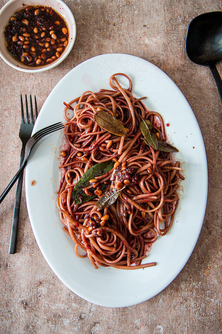 Spaghetti in red wine with pine nuts and sage