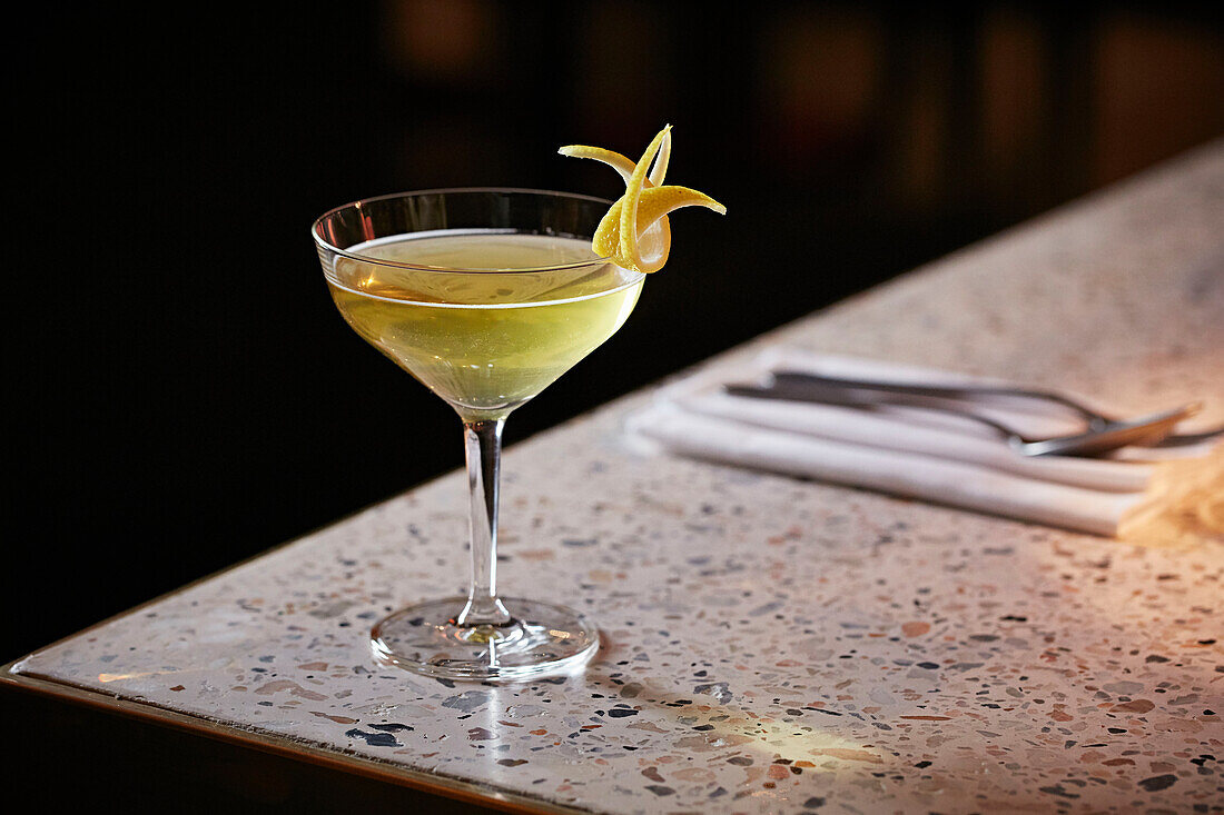 An elegant cocktail garnished with Lemon