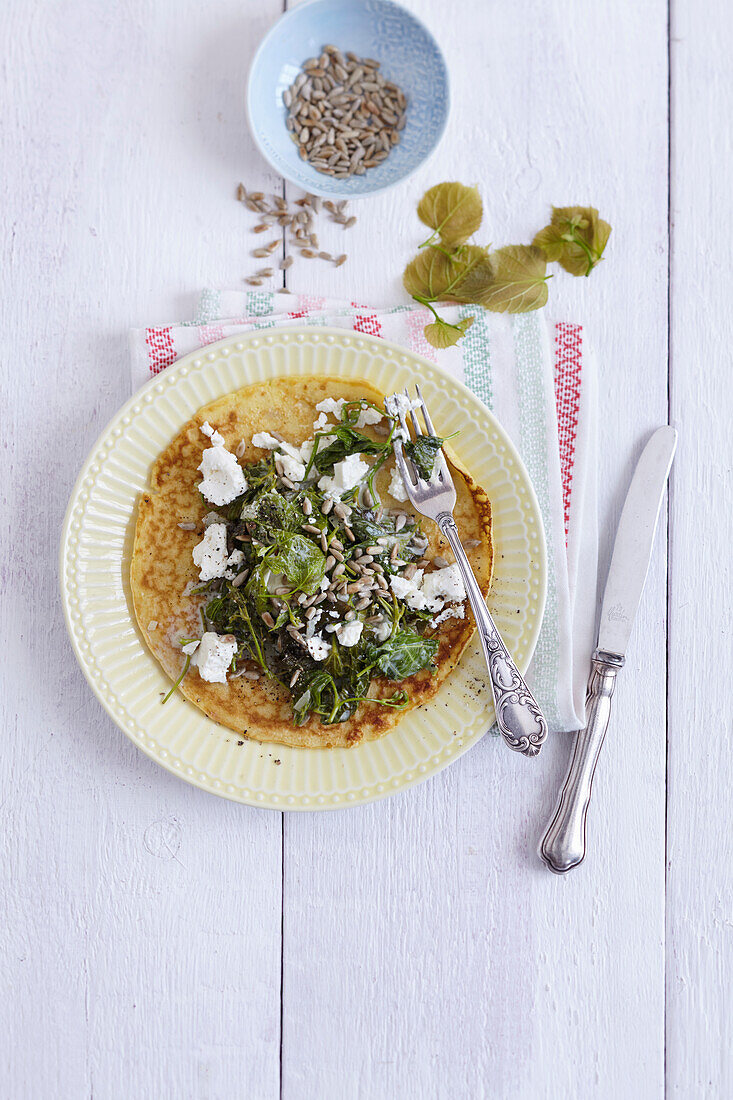 Lindenblattspinat mit Ziegenfrischkäse und Sonnenblumenkernen auf Pfannkuchen