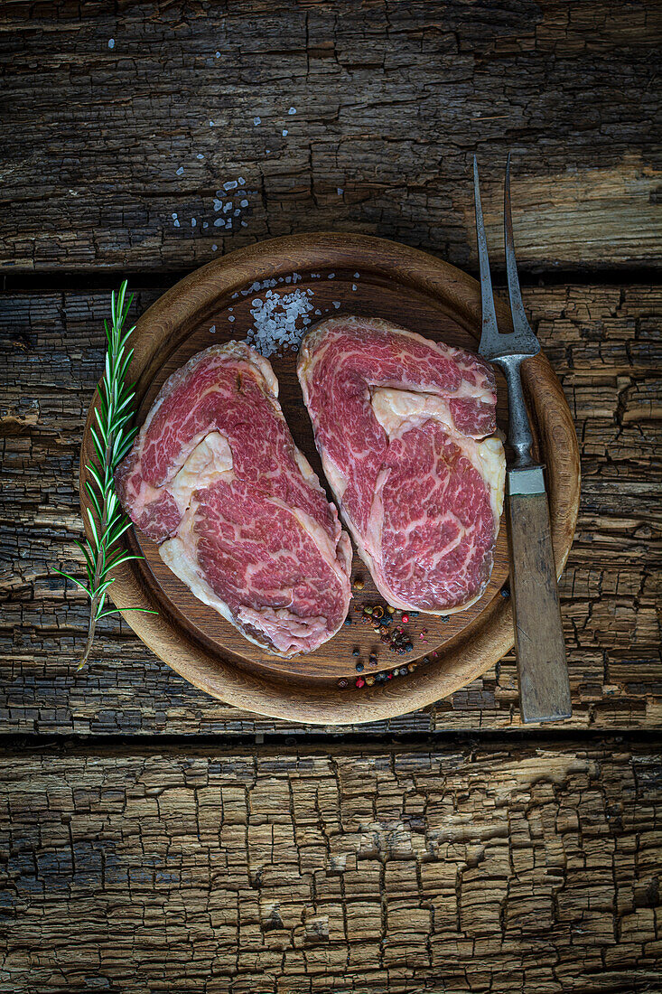 Rohe Ribeye-Steaks auf Holzbrett