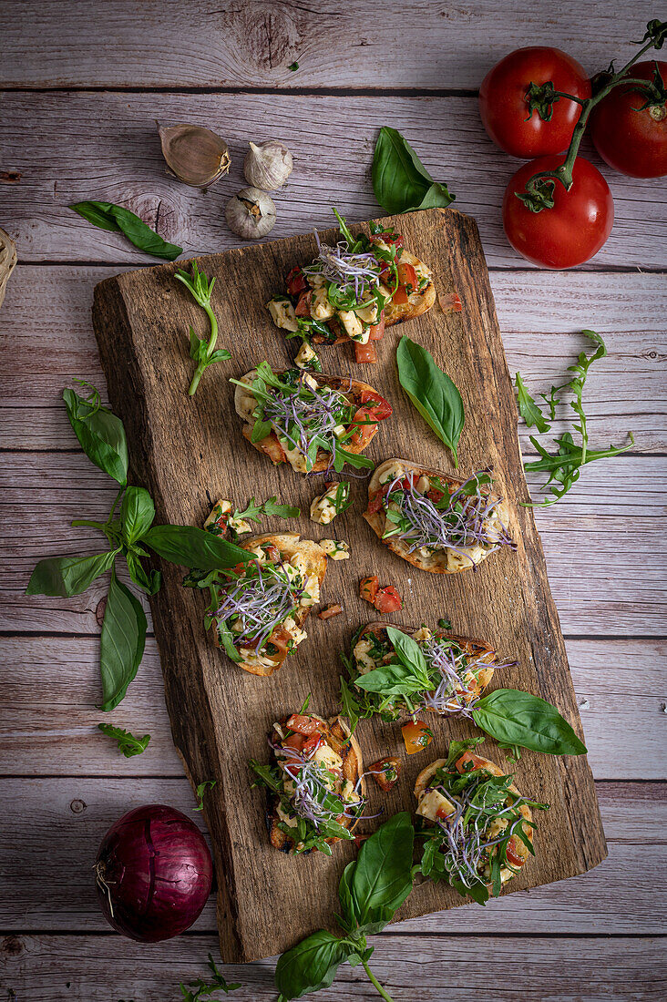 Bruschetta mit Sprossen auf rustikalem Holzbrett