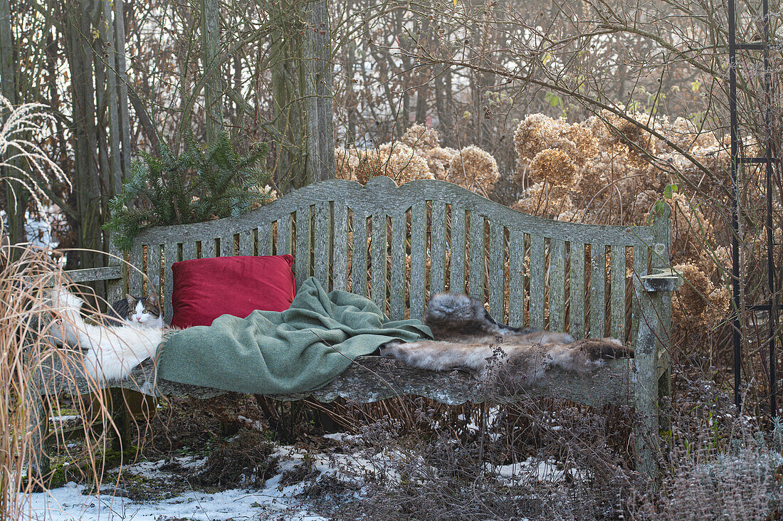 Garden bench with fur, cushions, and Christmas decoration