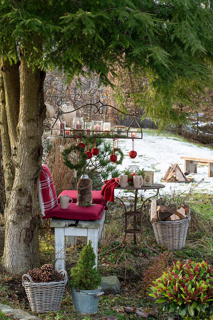 Christmas place in the garden - with cushions, hanging tray, lanterns, and Christmas tree balls wrapped with jute twine