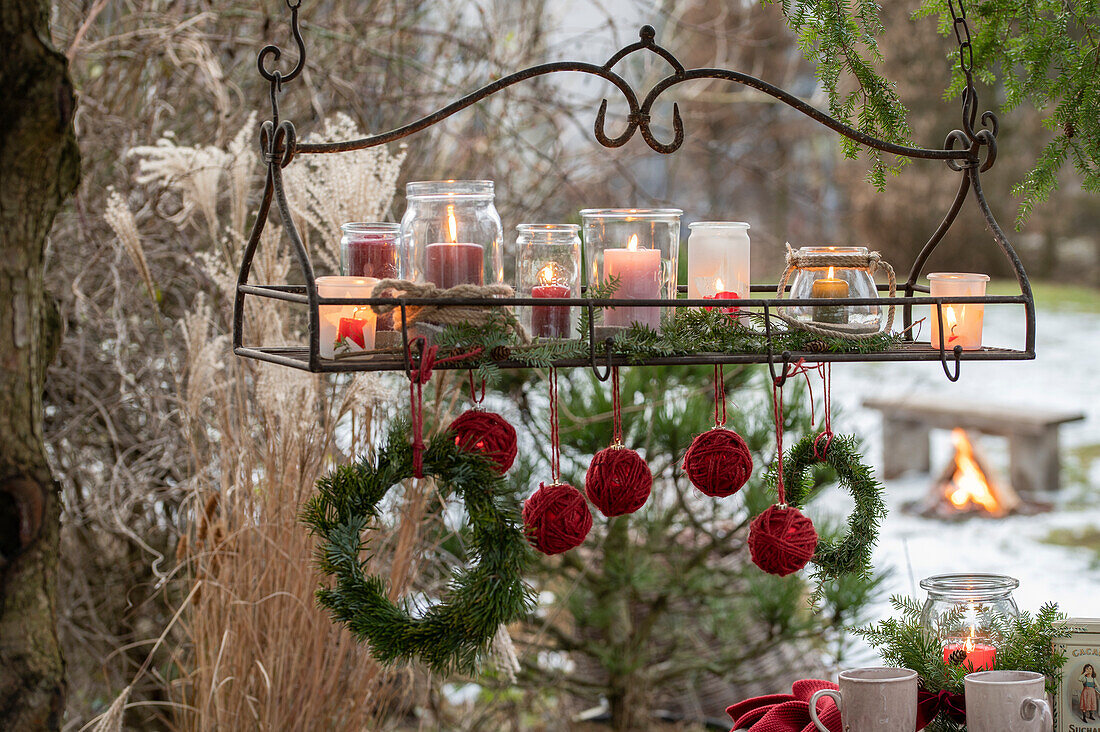 Hanging tray with lit candles and Christmas tree balls wrapped with jute string