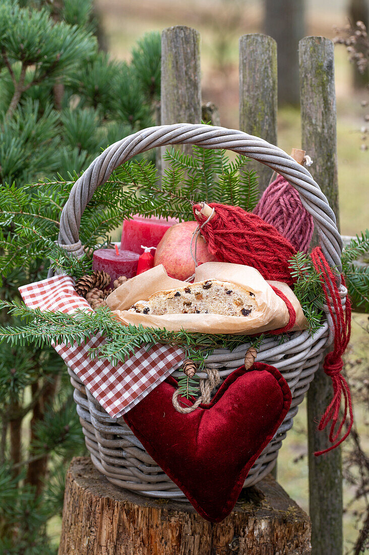 Christmas basket with stollen, candles, jute string, and heart pendant