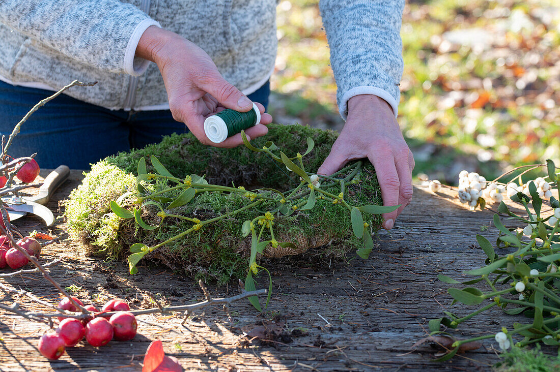 Wreath of moss, ornamental apples and mistletoe