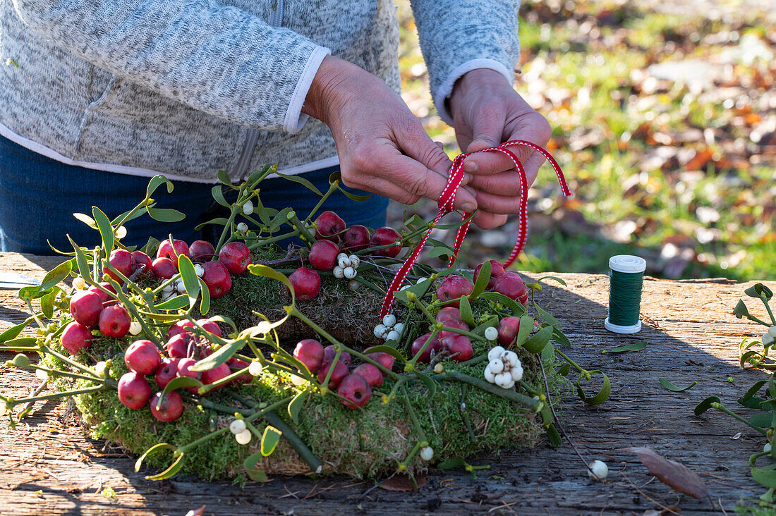 Wreath of moss, ornamental apples and mistletoe