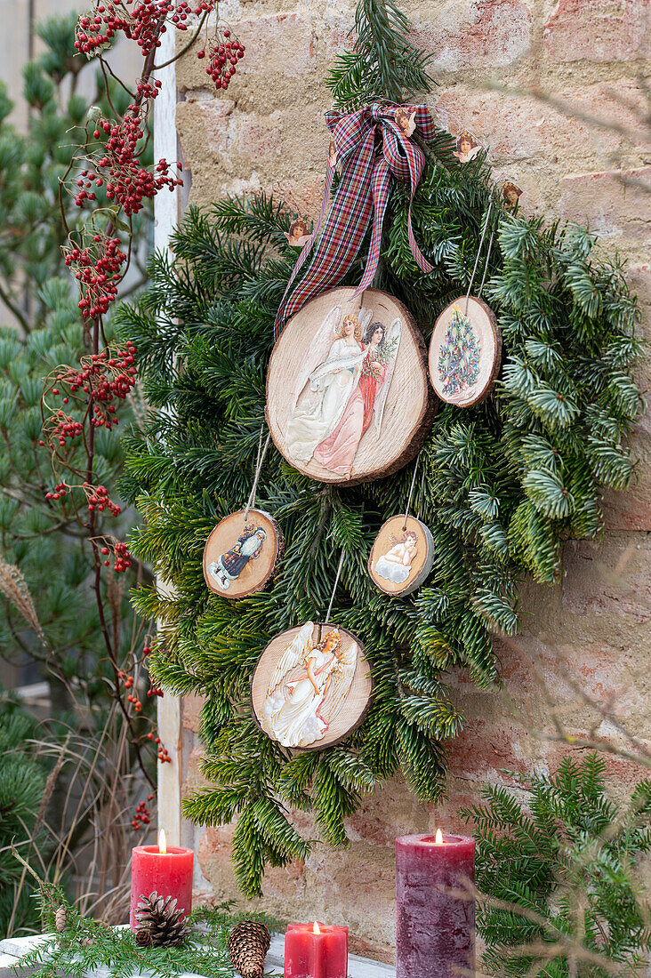 Nostalgically decorated wooden discs on fir branches (Abies nobilis)