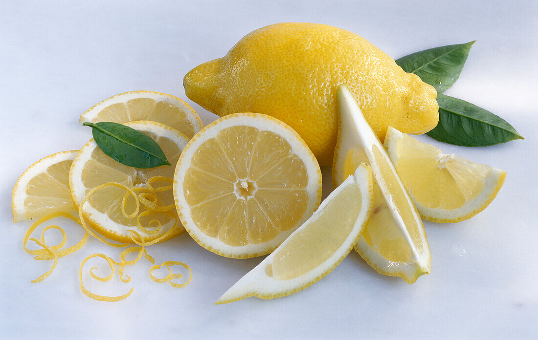 Stillleben mit Zitronen, Zitronenhälfte, Zitronenvierteln und Zitronenscheiben