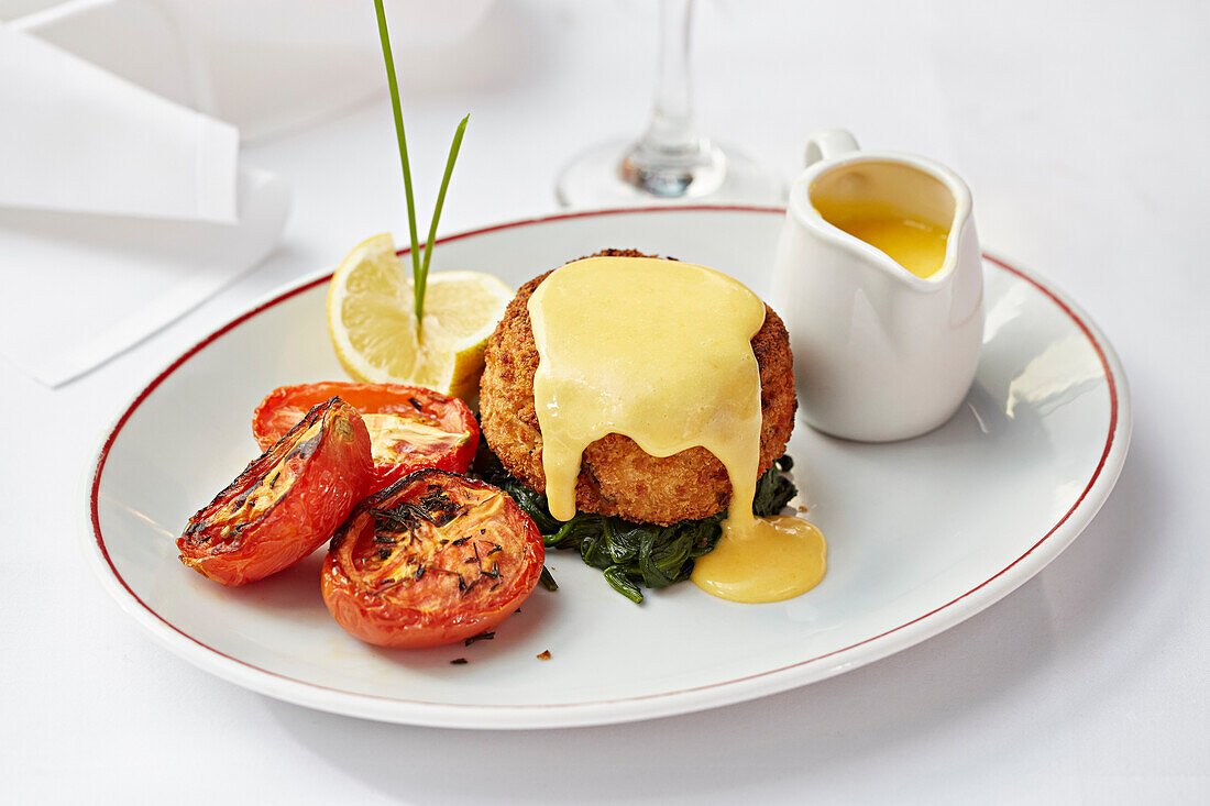 Fishcake on a bed of spinach served with a hollandaise sauce