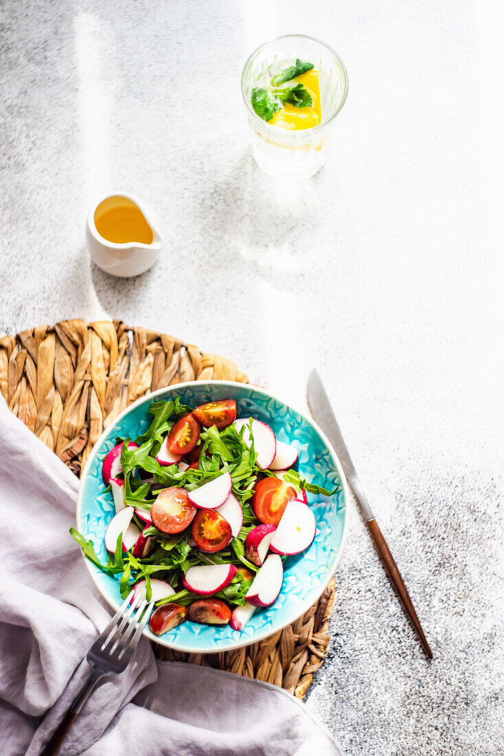 Healthy vegetable salad served in ceramic bowl on concrete table