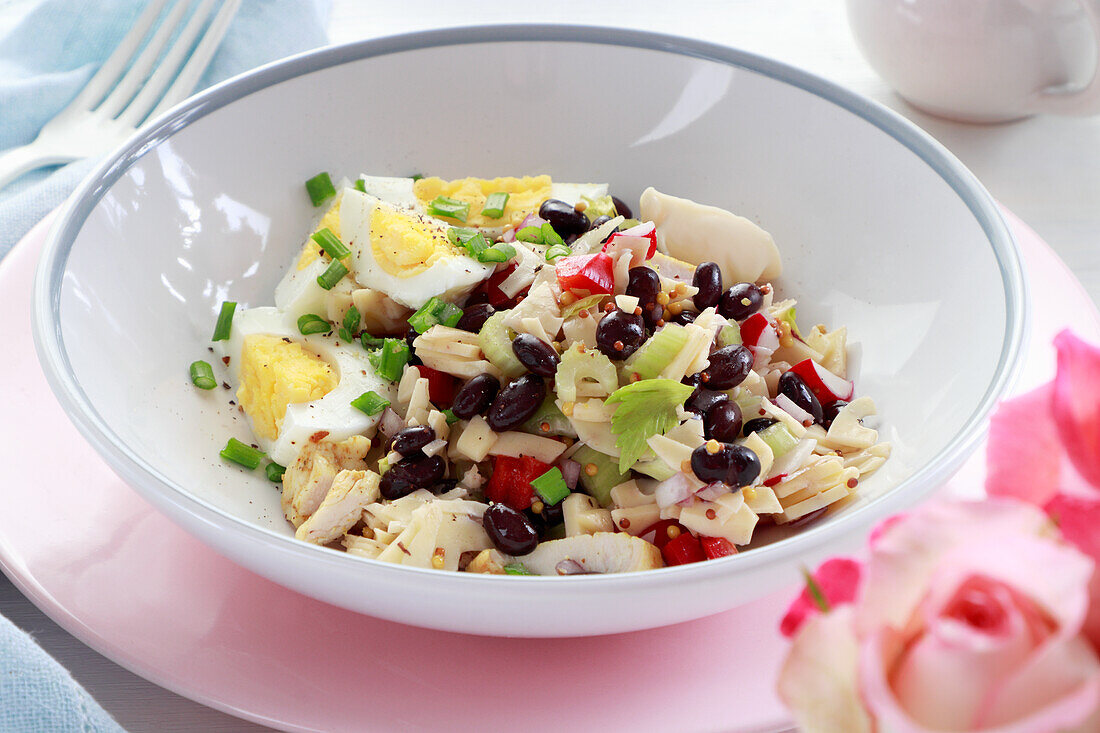Pasta salad with red beans, egg, chicken, radish, and pepper