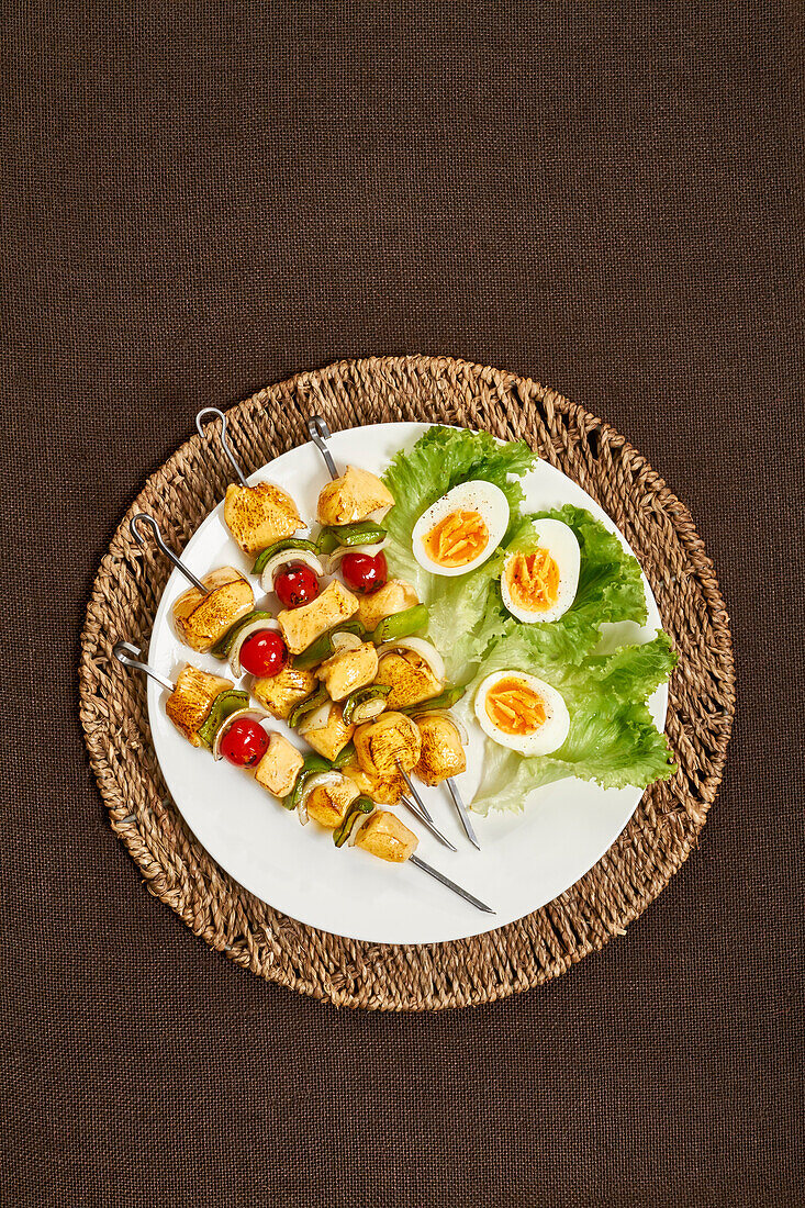 Hähnchen-Gemüse-Spieße und Salatgarnitur mit gekochten Eiern
