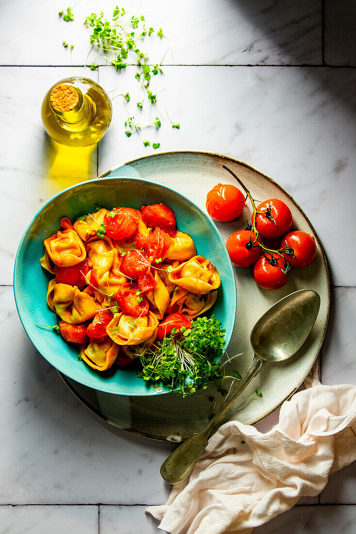 Cheese tortellini with stewed tomatoes and cress