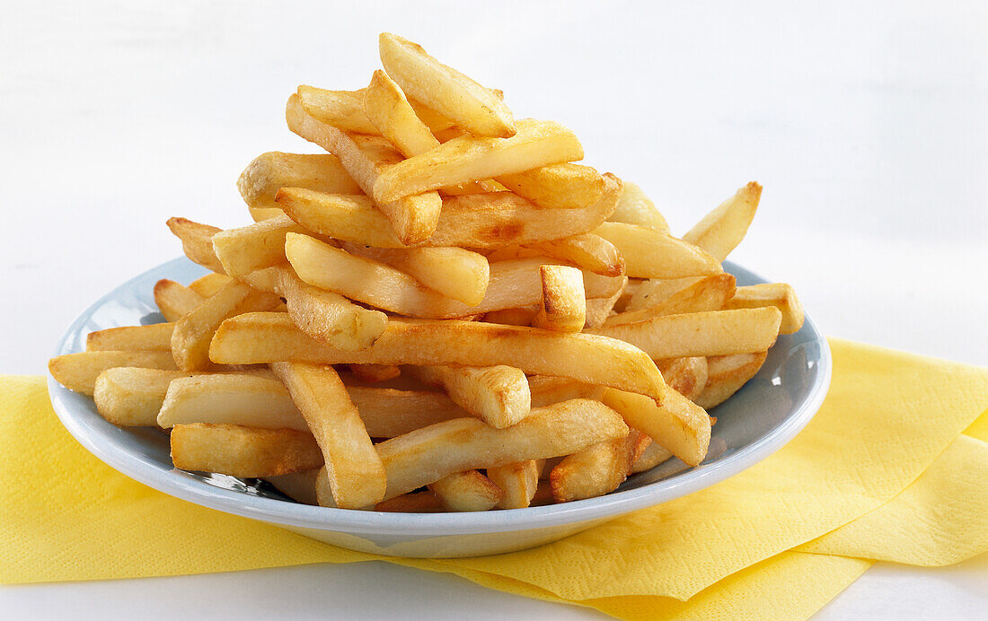 Plate with French fries on a yellow napkin