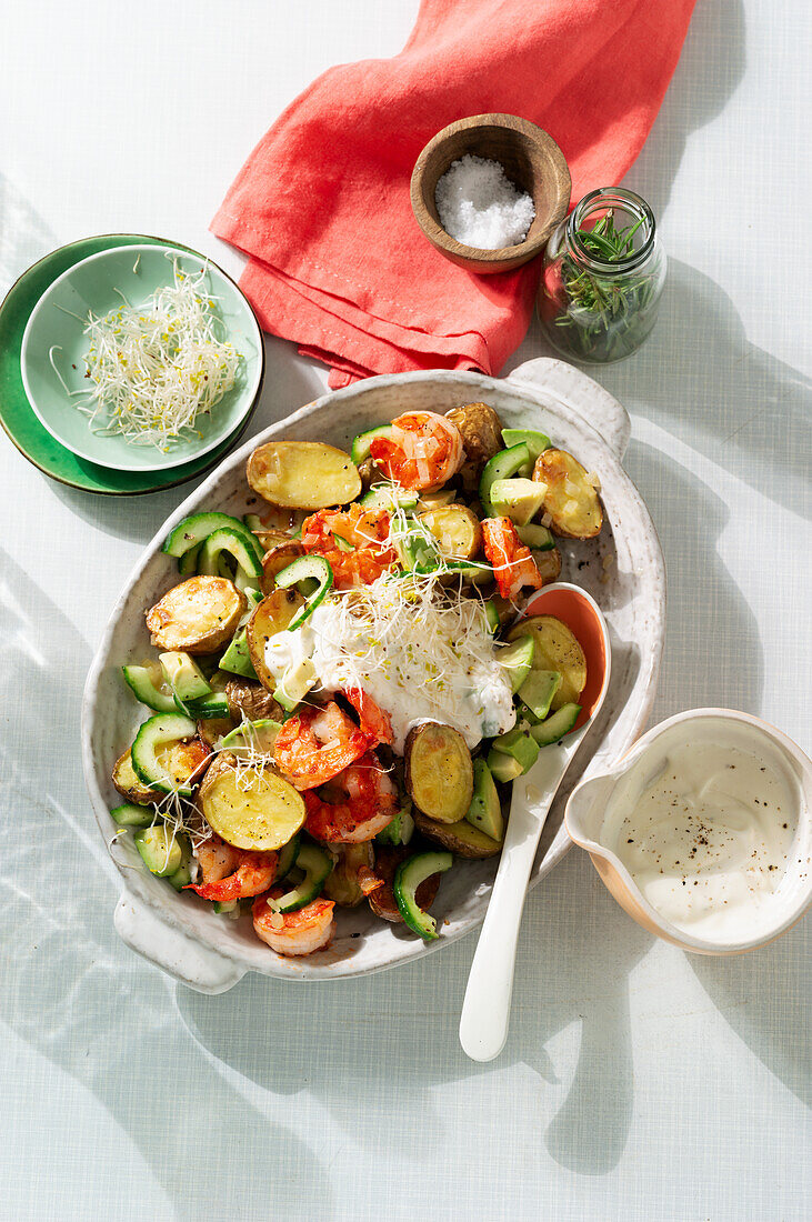Hot potato salad with avocado, prawns and sprouts