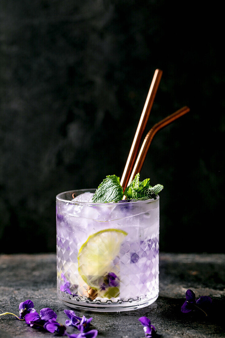Limonaden-Soda-Cocktail mit Veilchenblüten-Eiswürfeln und Zitrone
