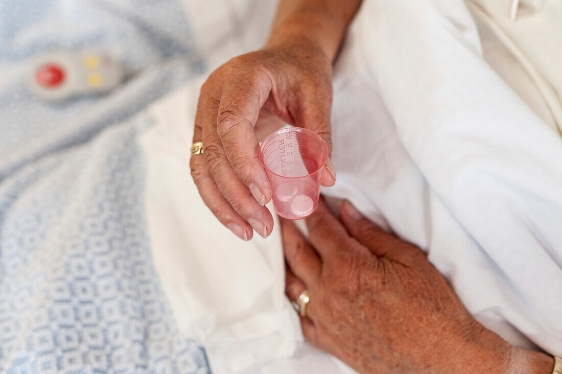 Patient holding a cup containing medication