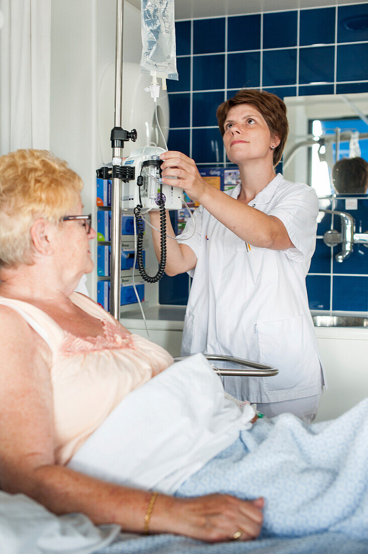 Nurse preparing an IV for a patient in bed