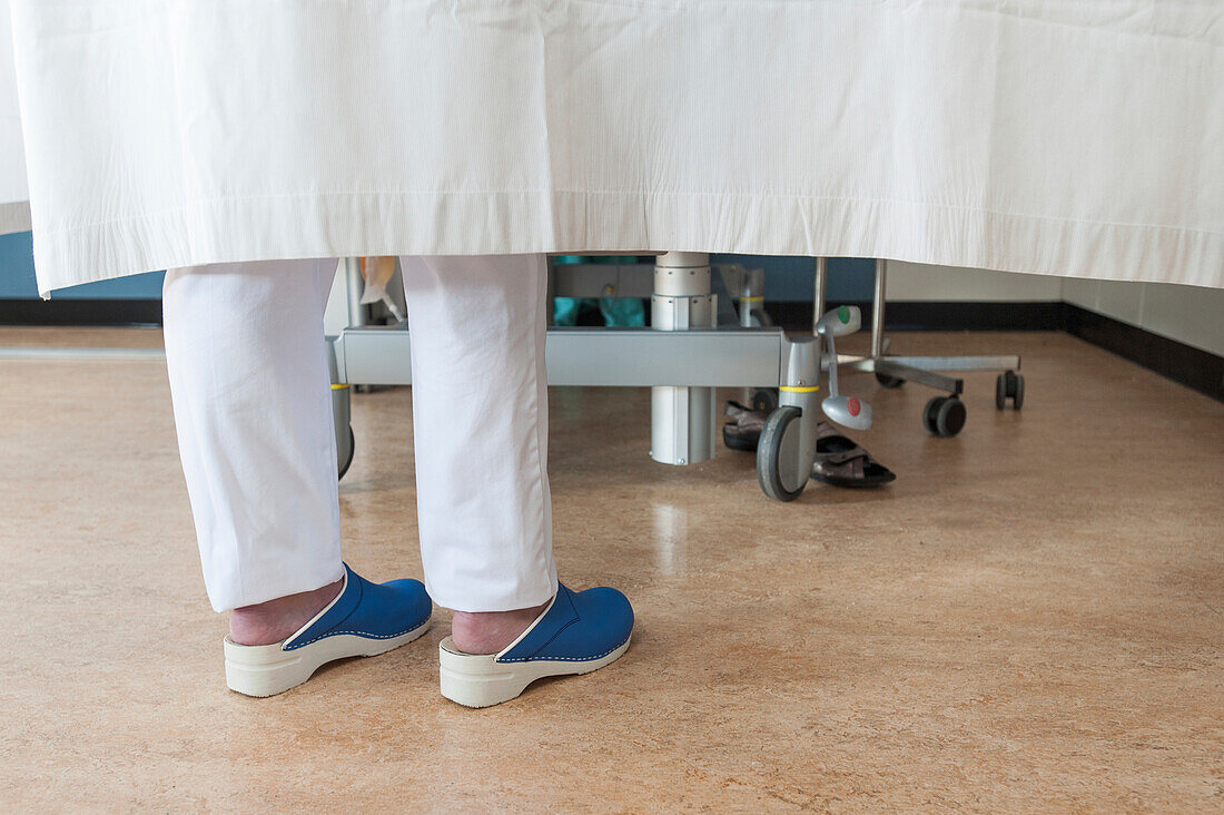 Feet of a nurse at a patient's bedside