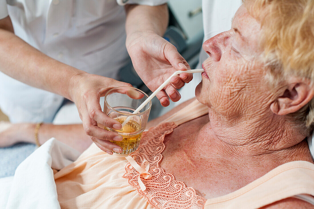 Nurse helping a patient with a drink