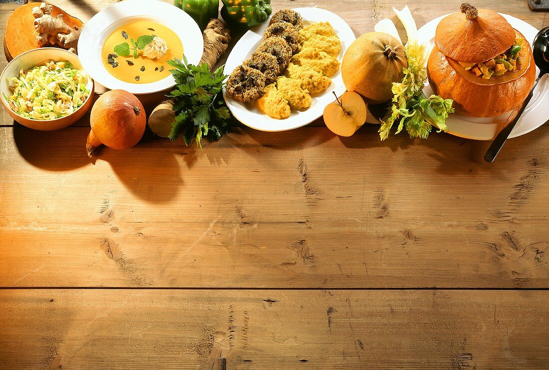 Various pumpkin dishes in a row on wooden background