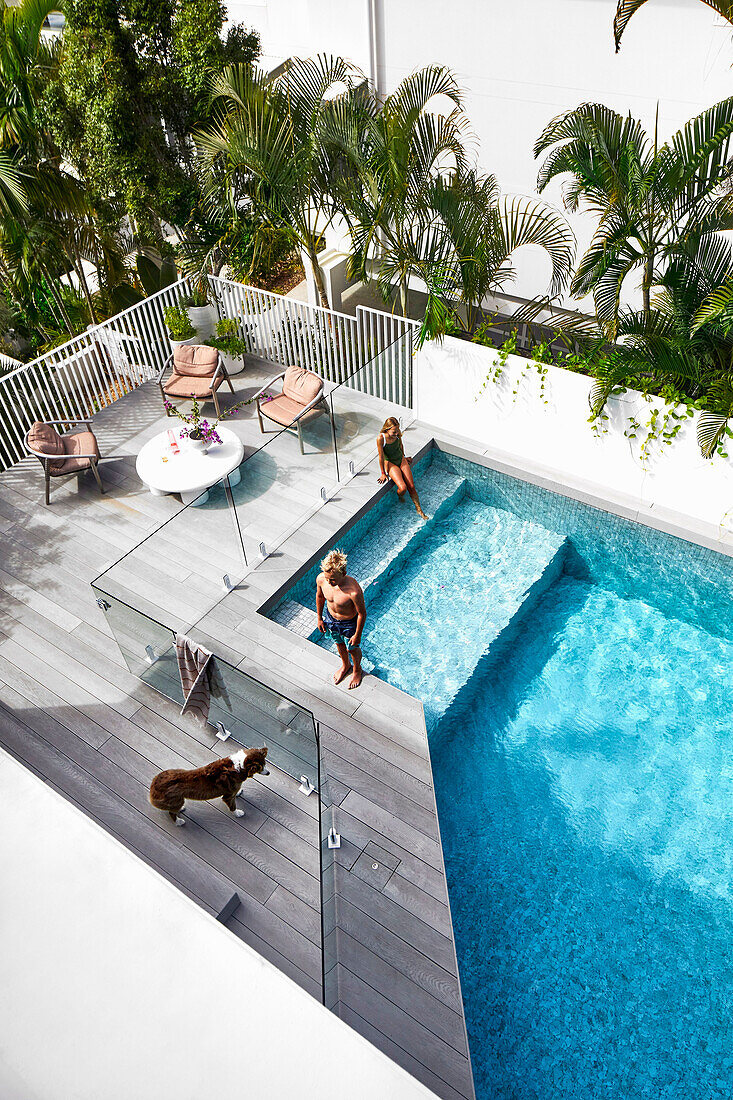 Blick von oben auf Pool und Terrasse mit Glastrennwänden