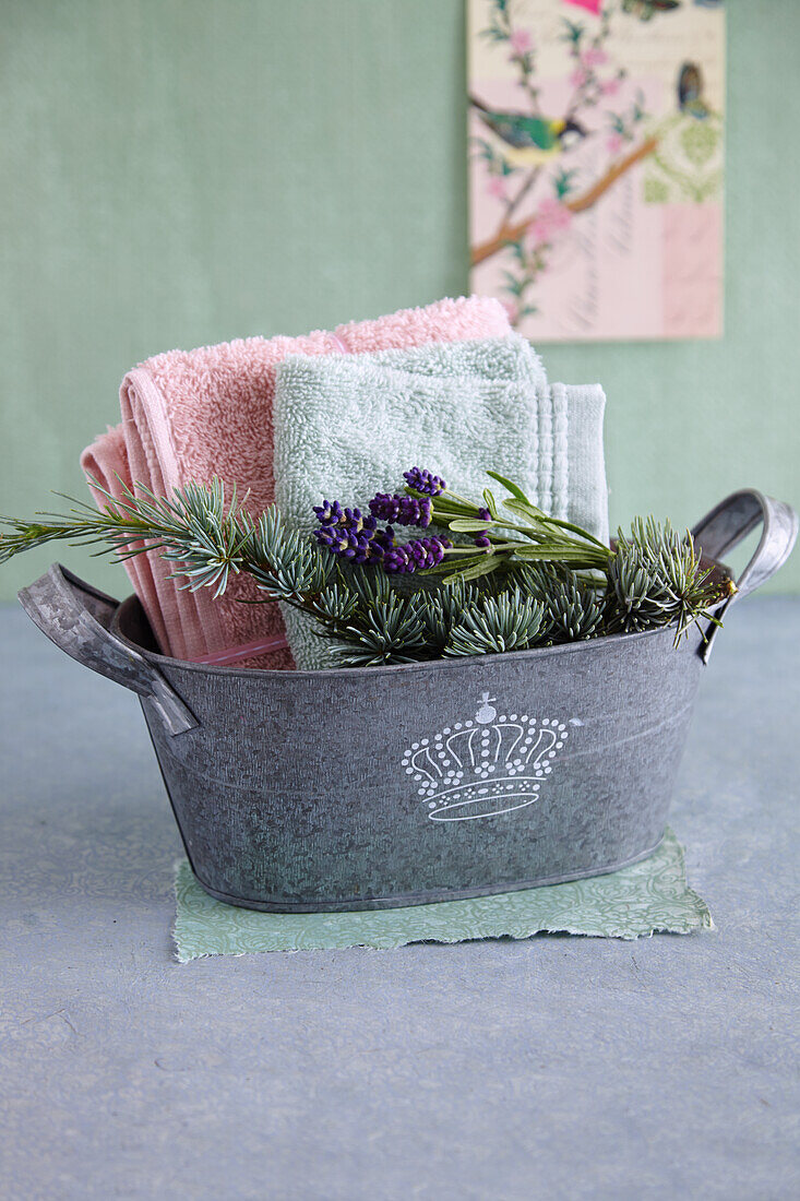 Ingredients for a foot bath and towels in a small zinc tub